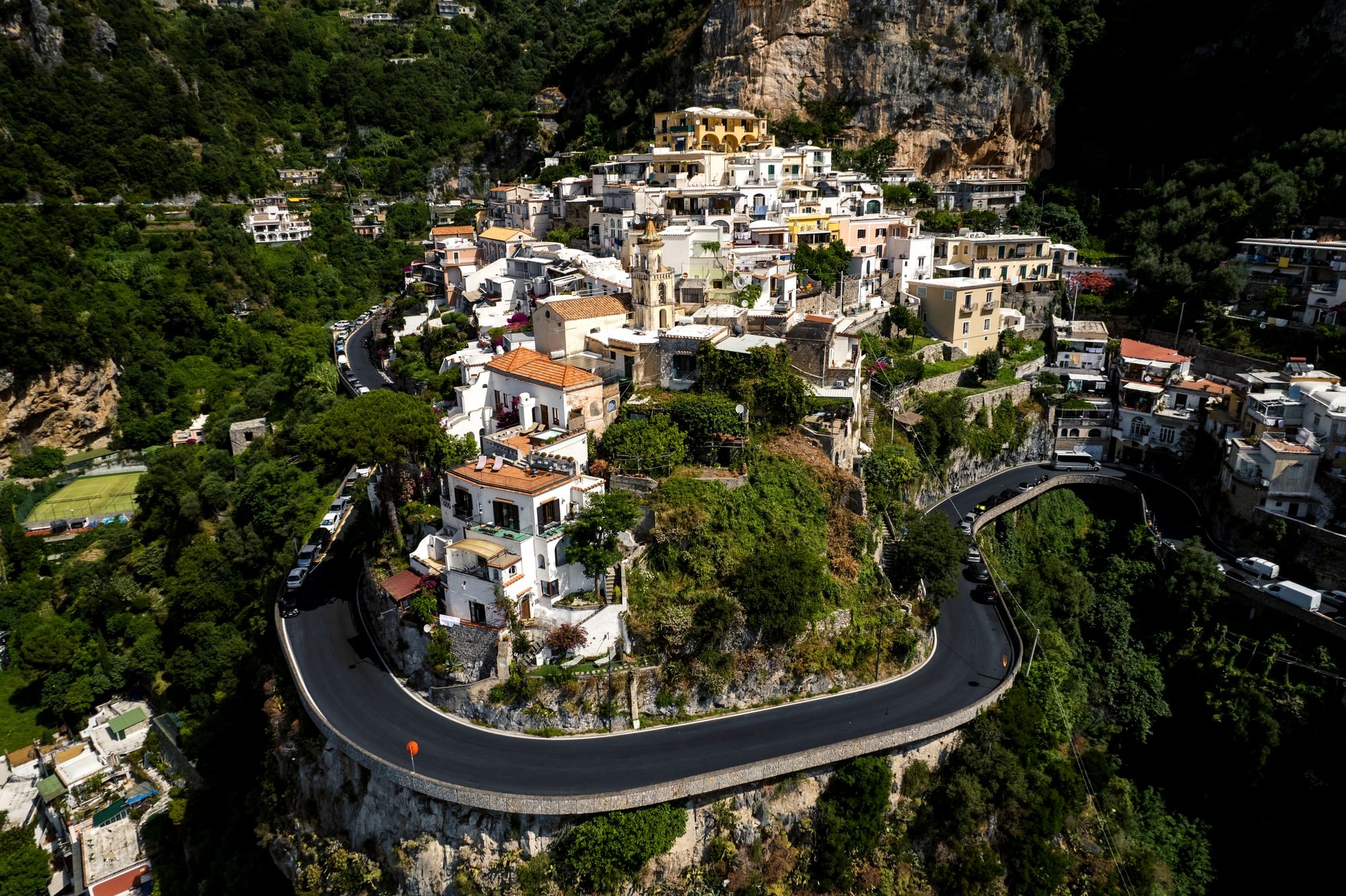 A blue SITA bus on the winding Amalfi Coast road high above the sea