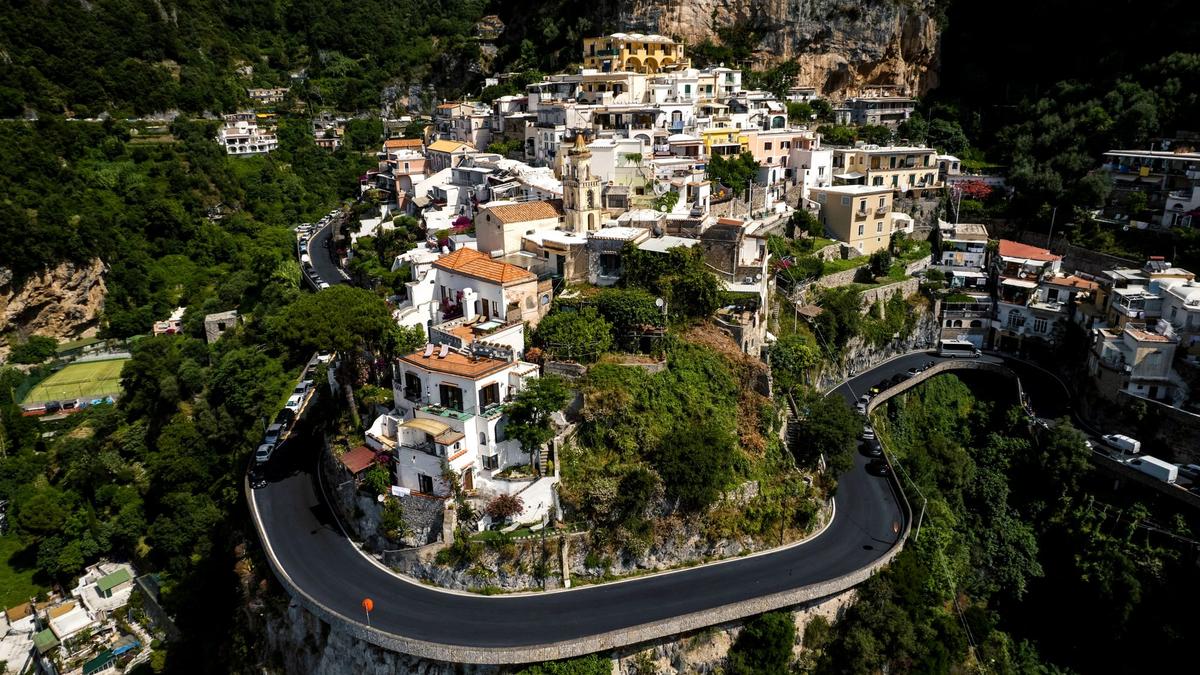 A blue SITA bus on the winding Amalfi Coast road high above the sea