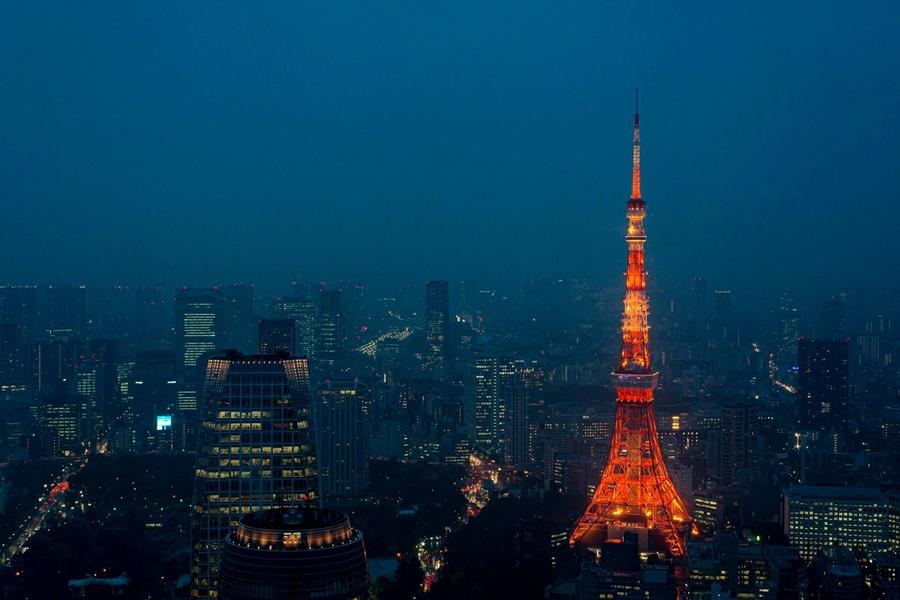Neon-lit Tokyo skyline at night with crowded streets and glowing signs