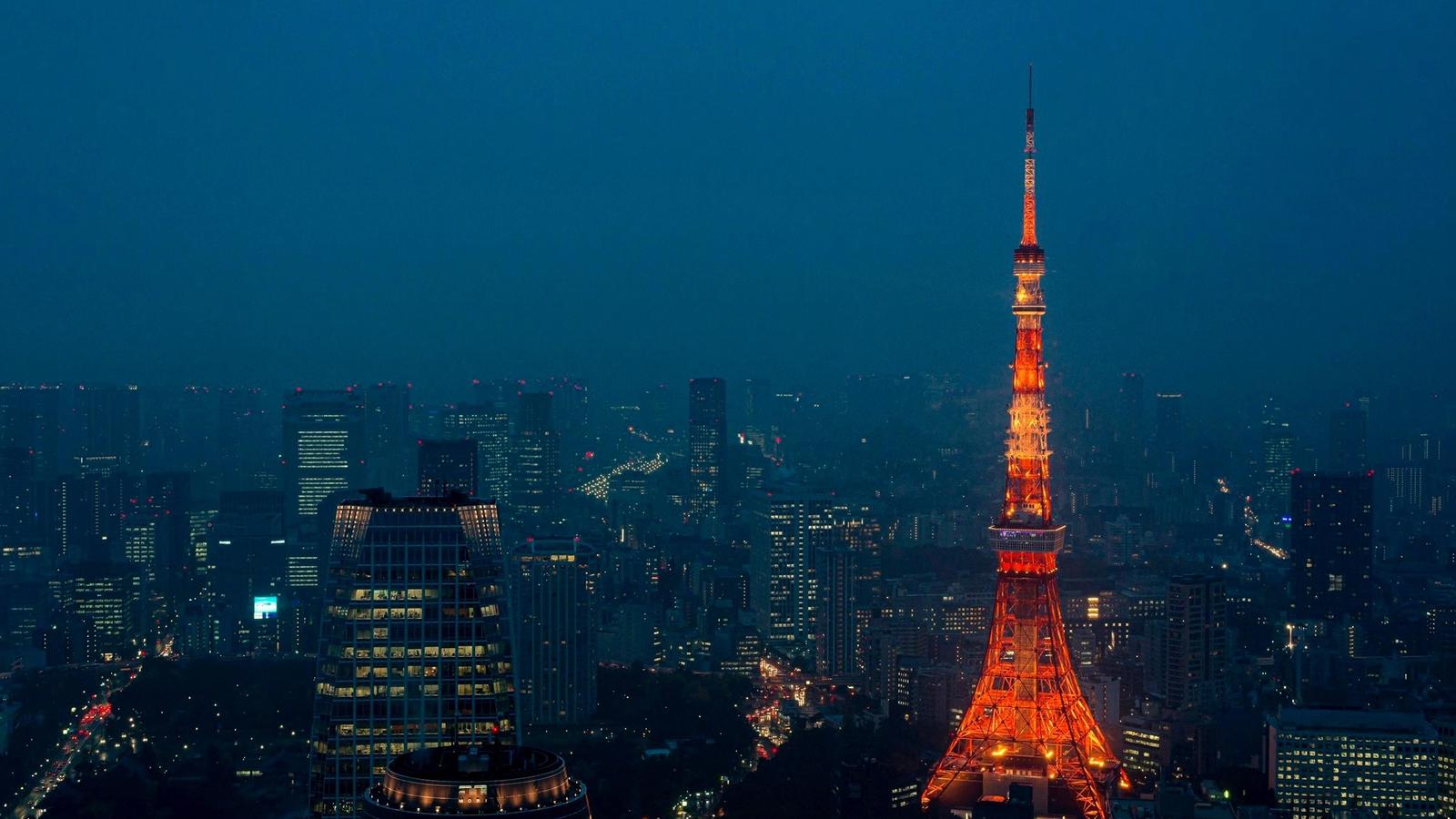 Neon-lit Tokyo skyline at night with crowded streets and glowing signs