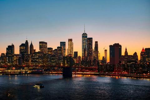 Yellow taxis on a Manhattan street below the New York City skyline