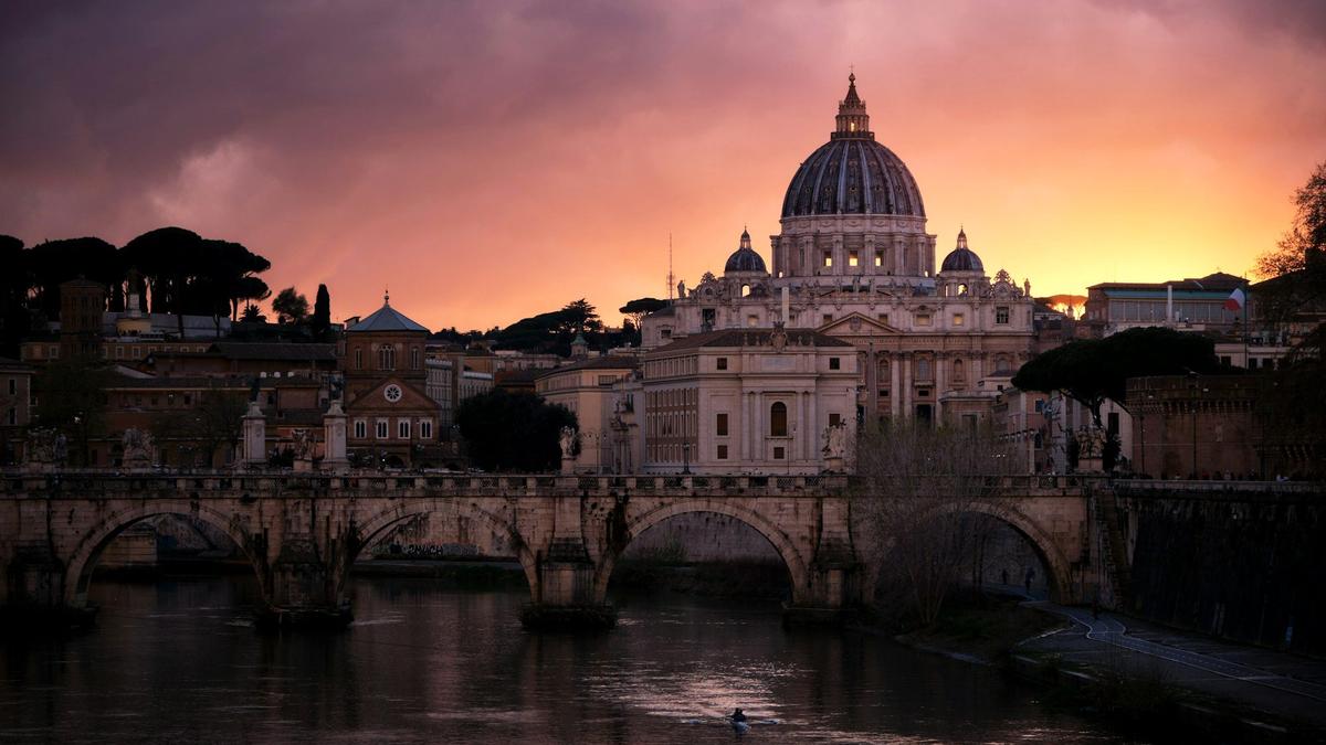 St. Peter's Basilica dome glowing at sunset above the Tiber River near Rome's Prati district