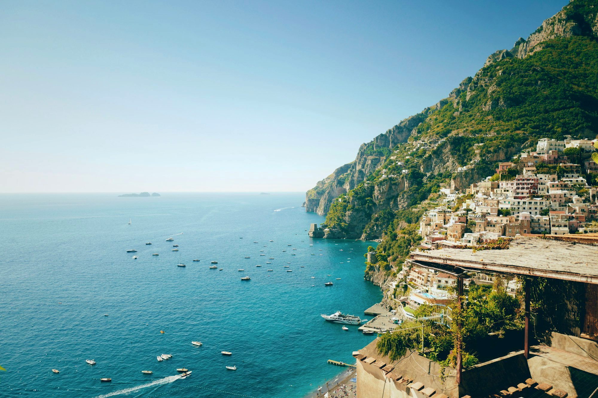 A blue SITA bus on the winding Amalfi Coast road high above the sea