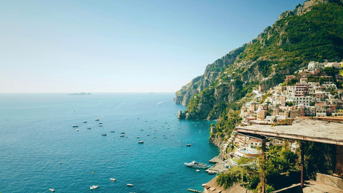 A blue SITA bus on the winding Amalfi Coast road high above the sea