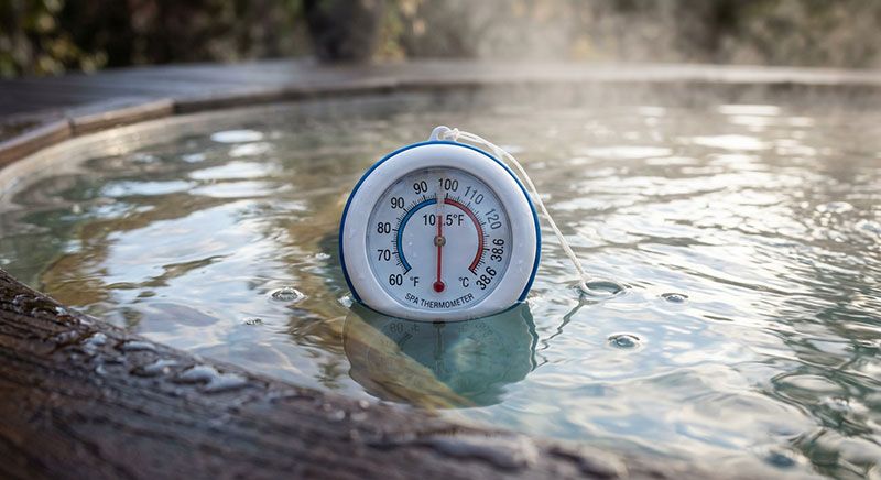 Spatermometer i ångande varmt spabad visar cirka 38,6 grader Celsius