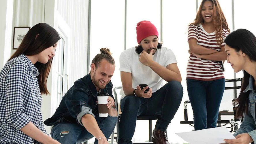 Creative team gathered around papers on the floor during an energetic brainstorming session