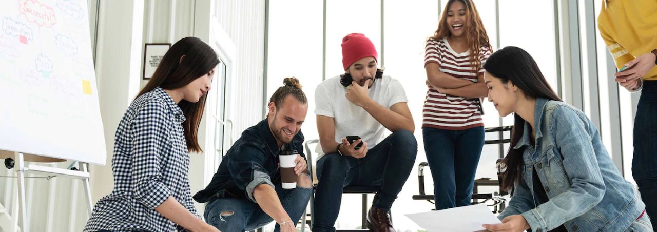 Creative team gathered around papers on the floor during an energetic brainstorming session