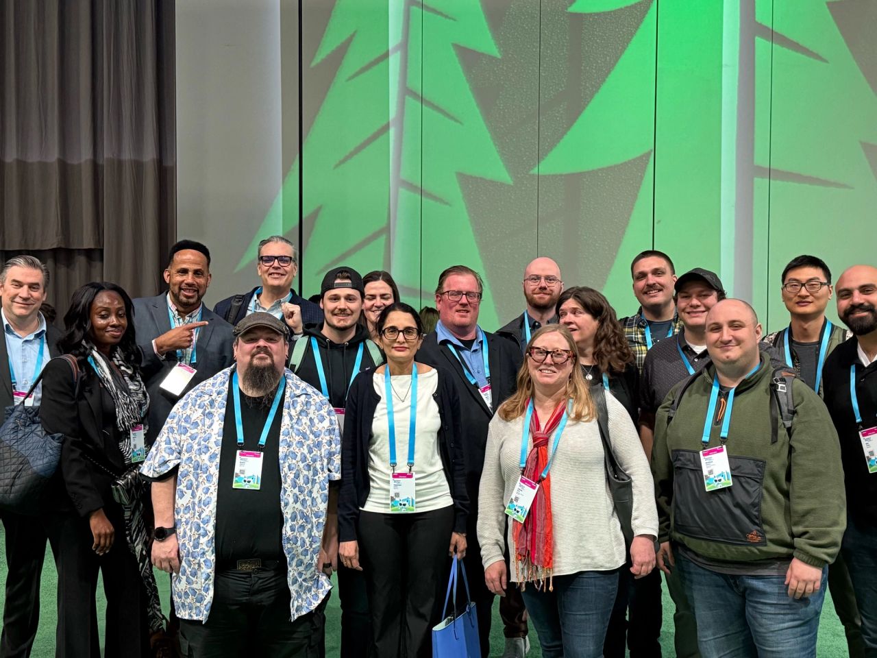 AgencyQ team group photo at Salesforce Dreamforce conference with green branded backdrop