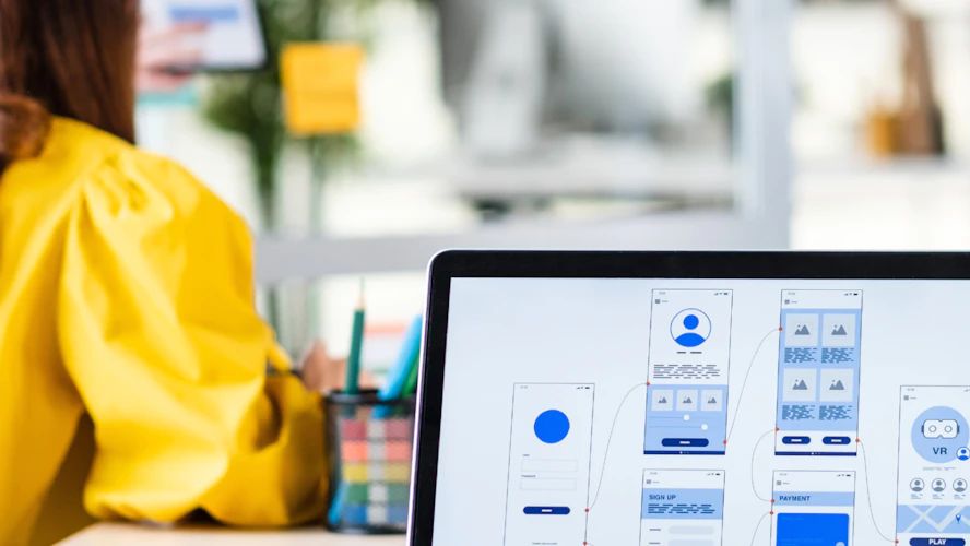 Designer reviewing mobile app wireframes on a laptop screen