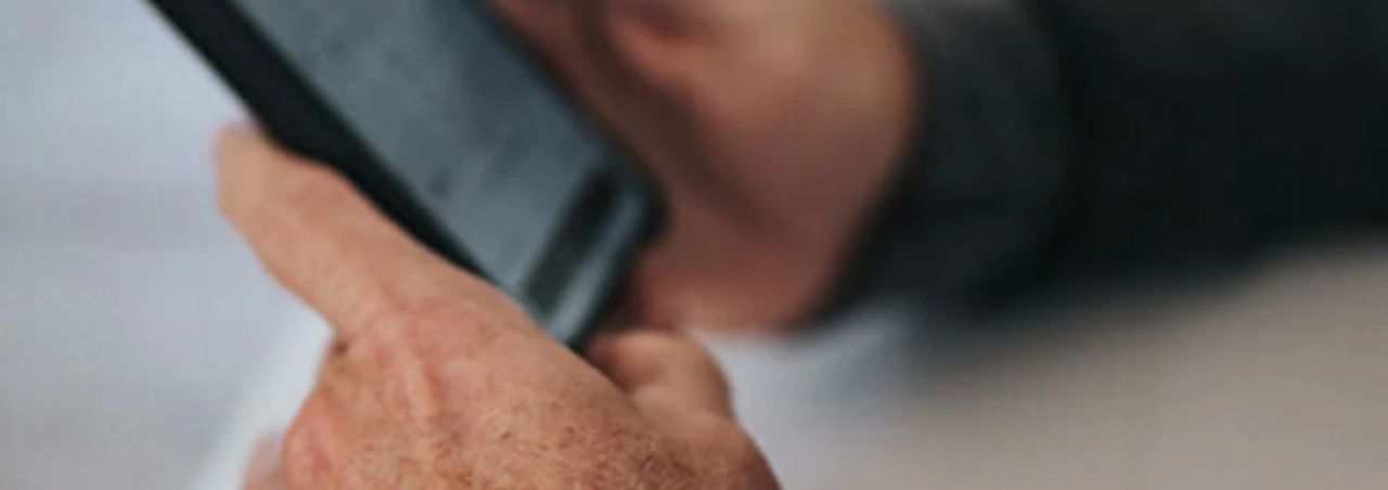 Close-up of a hand holding a smartphone, softly blurred