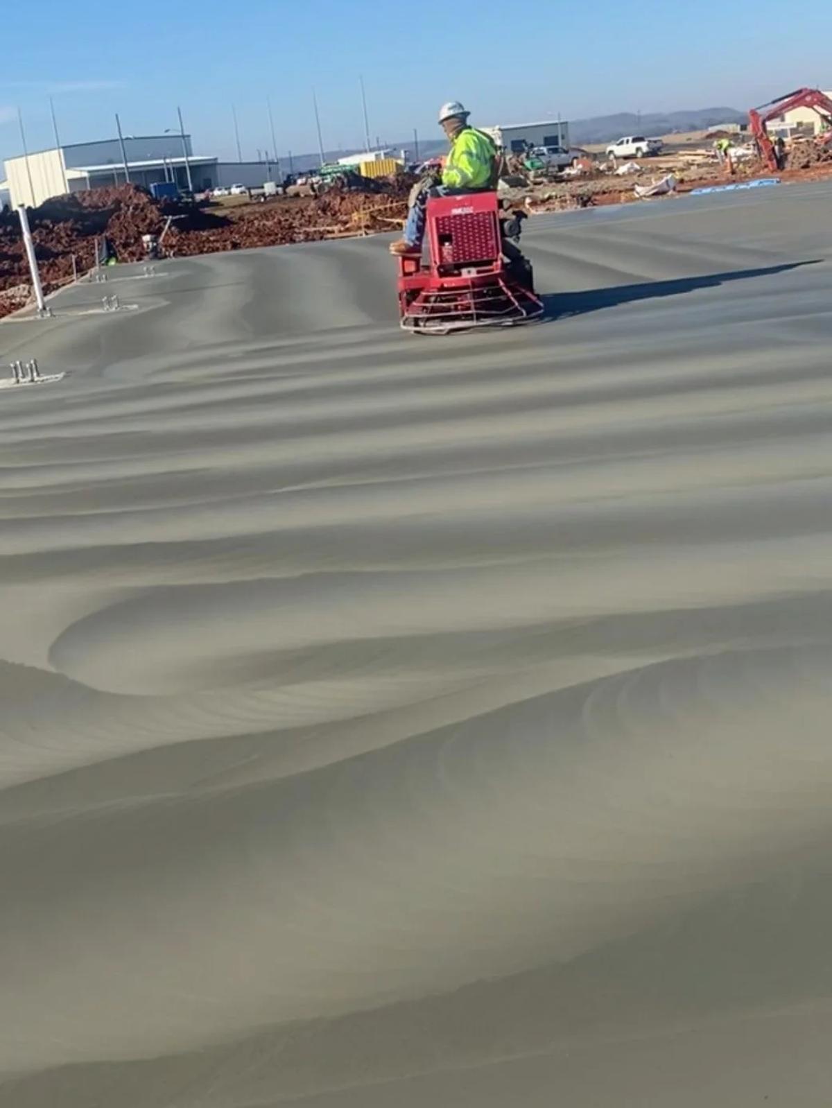 An AIC crew member finishing a large concrete slab