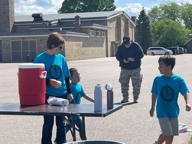 Walkers Madden Dischler (1) and Gabe Ledesma (1) "round the bend " by the water station supervised by Julie Wuerger.