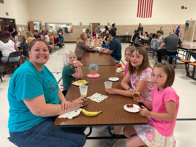 Mom Michelle Ziegler takes time to eat healthy fruit with her daughters Carmen (1 - front) and Savannah (4). Next to Savannah is Cloudia Haselwander (4) and next to Michelle, Kyra Muller (1).