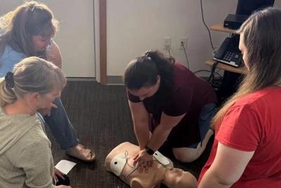 Teachers practicing CPR on training manikins.