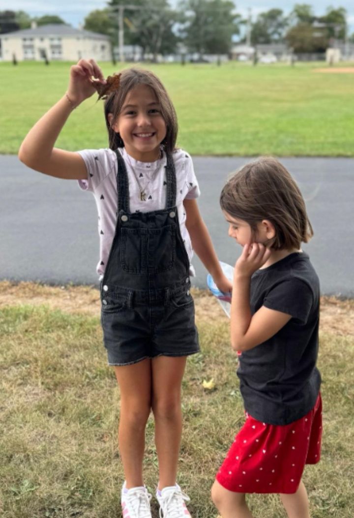 A second grader holding up a leaf found during the scavenger hunt.