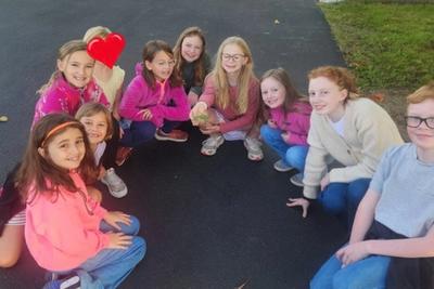 Students gathered in a circle on the blacktop at morning recess.