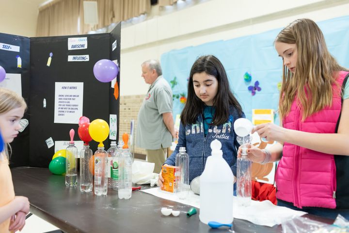 Clara Galvez and Laura Kruchten (5) show how to make balloons self-inflate