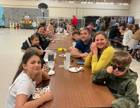 (Right) Parents Mike & Leah Ederer enjoy sweets with their sunglassed son Logan (3). Others joining include (front, going clockwise) Valentina Brum (3), Adalynn Kasper (2), mom Roberta Kasper, James Kasper (K) and Sam Ederer (4 - cousin, behind Mike).