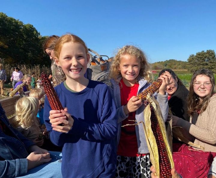 Students holding up the colorful Indian corn they picked.