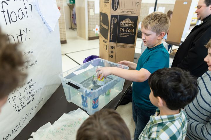 Ethan Kruchten (not in photo) and Calvin Breunig (5) explain why some pop cans float and others don't.