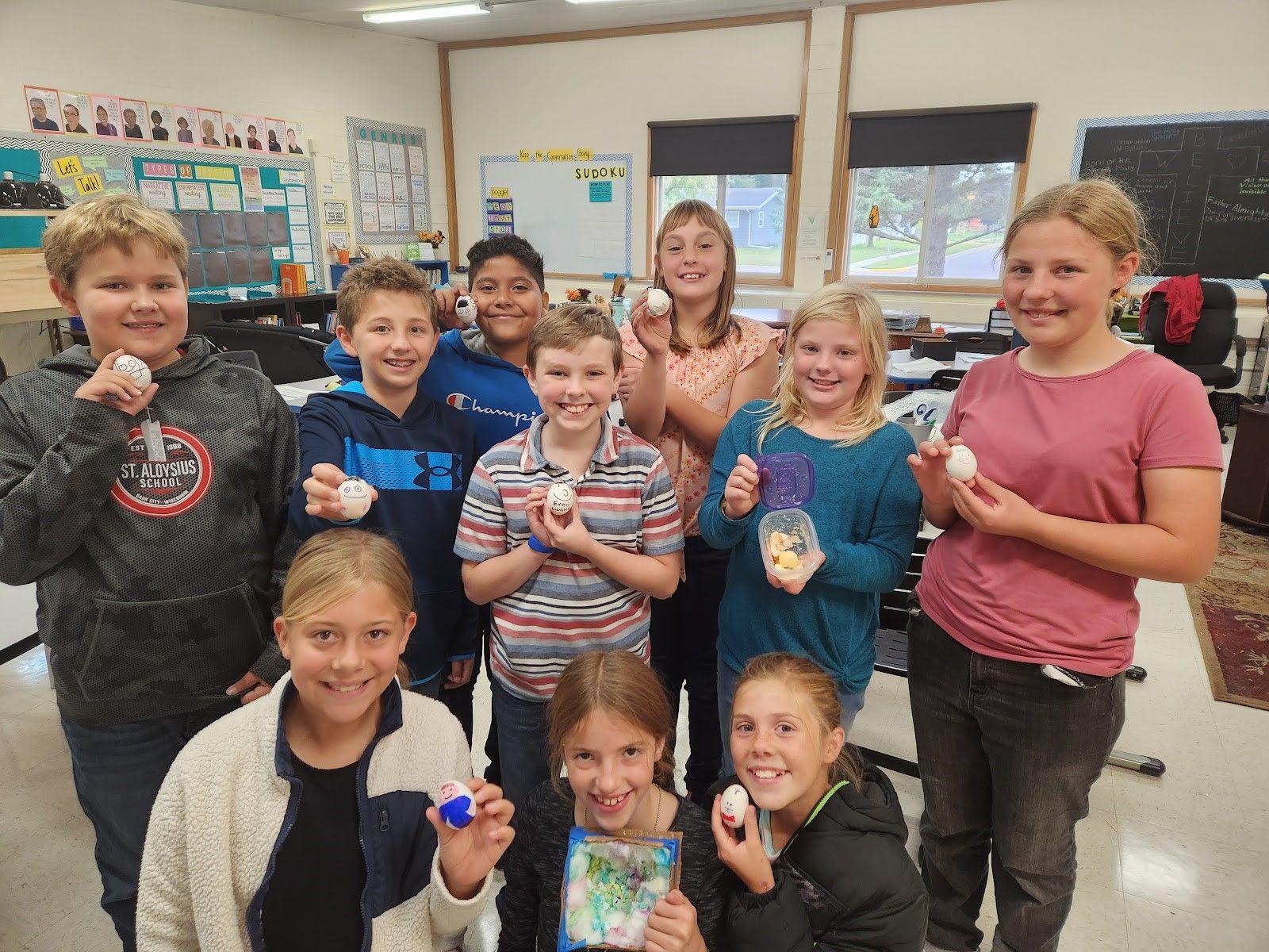 Mrs. Hruby's 5th grade class poses with their eggs (aka their "souls"): Front L to R: Cloudia Haselwander, Lucy Sauter, Brynn Dischler. Middle L to R: Matthew Heiney, Sam Ederer, Evan Cunningham, Rhylan Muller, Meg Brickl. Back L to R: Emmanuel Alvarado and Savannah Ziegler.
