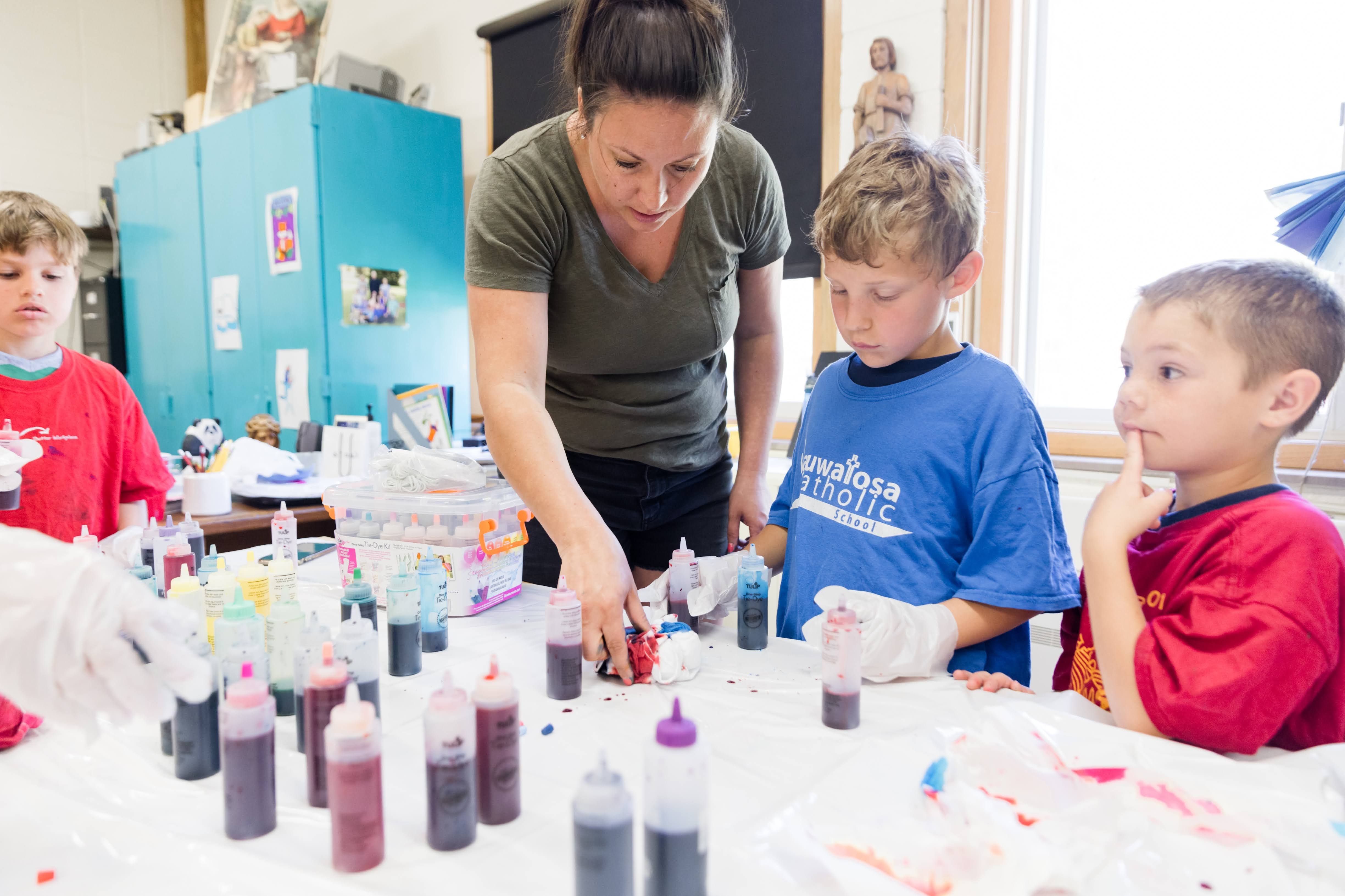 Logan Ederer (3), Jack Brickl (1) and Madden Dischler (1) learned how to tie-dye t-shirts from parent Lindsey Dent.