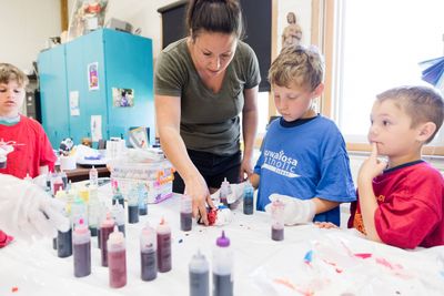 Logan Ederer (3), Jack Brickl (1) and Madden Dischler (1) learned how to tie-dye t-shirts from parent Lindsey Dent.