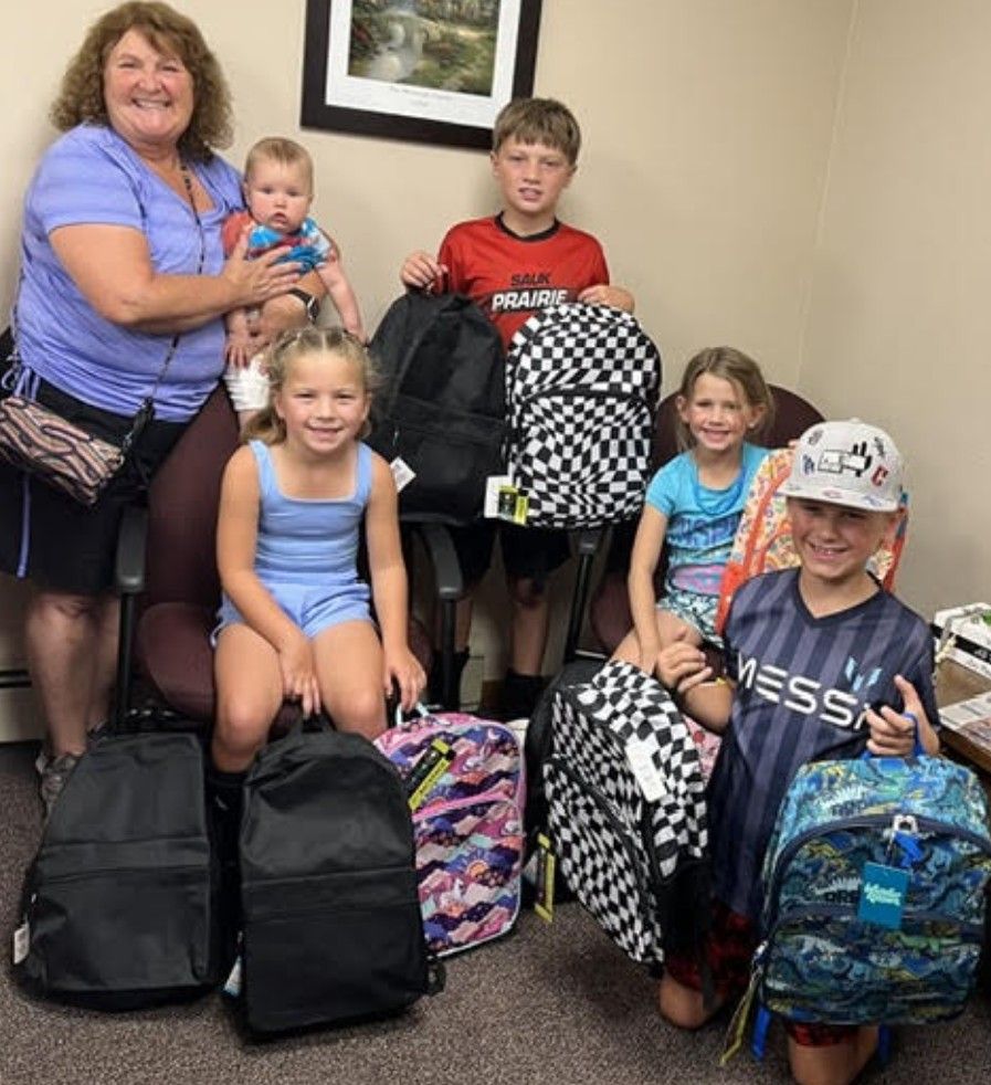Brenda Murphy with her grandchildren and a pile of donated backpacks.
