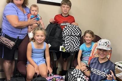 Brenda Murphy with her grandchildren and a pile of donated backpacks.