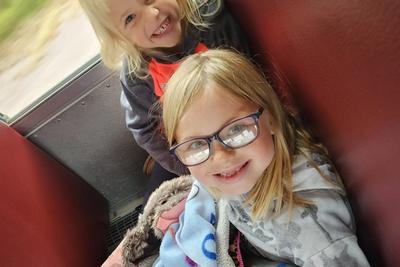 Eve Sauter (K) and Kensi Hrubi (1) show how happy they are to ride the bus together.
