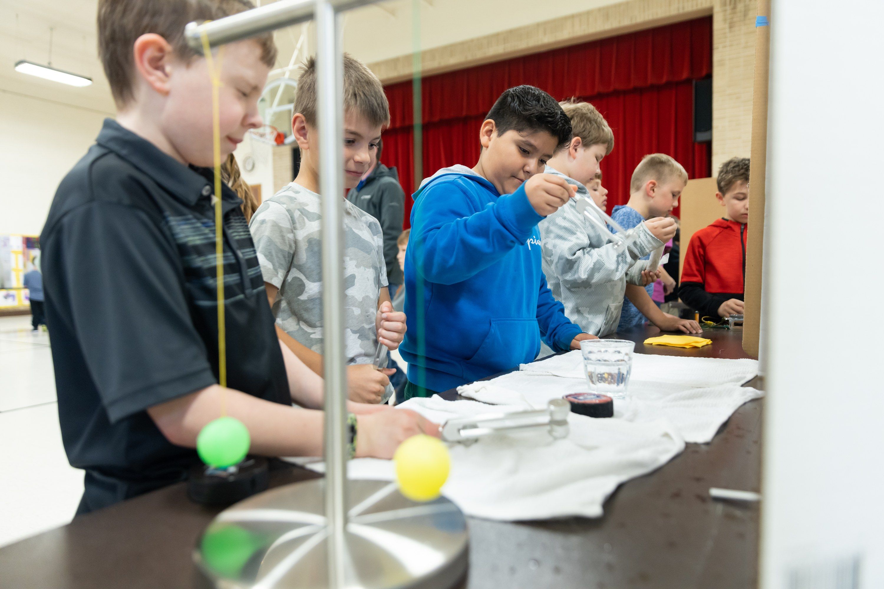 Older students test a pendulum experiment at the science fair.