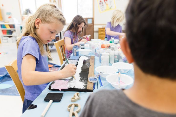 Stella Wuerger (front) and Rosie Moss (back) paint wooden signs during "Crafts with Nicole."