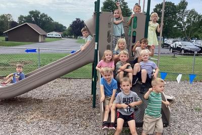 Students gathered on the playground climbing structure during the first days of school.