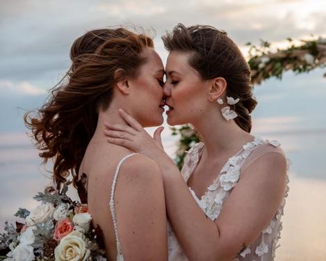 Gleichgeschlechtliches weibliches Brautpaar küsst sich 