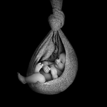Awake baby in a hanging womp wrap in black and white