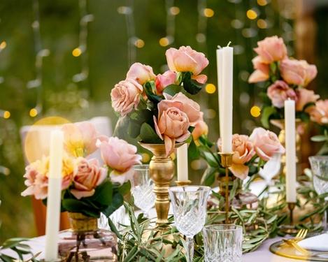 Schön geschmückter Hochzeitstisch mit Kerzen und lachsfarbigen Rosen