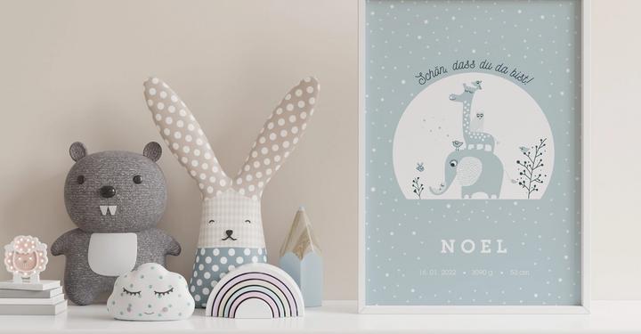 Name poster in white frame with light blue children illustration next to stuffed animals 