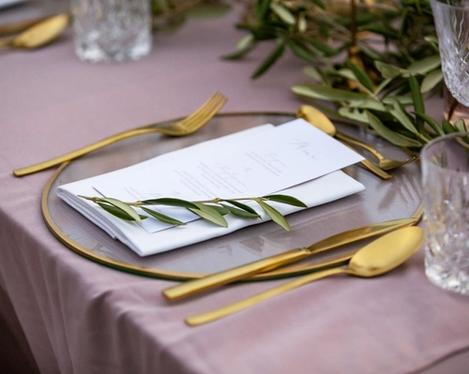Place setting with gold framed glass plate and gold cutlery from the wedding table