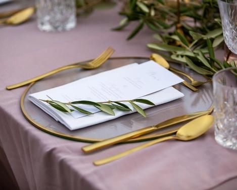 Gedeck mit Gold umrahmte Glasplatte und Goldbesteck von der Hochzeitstafel