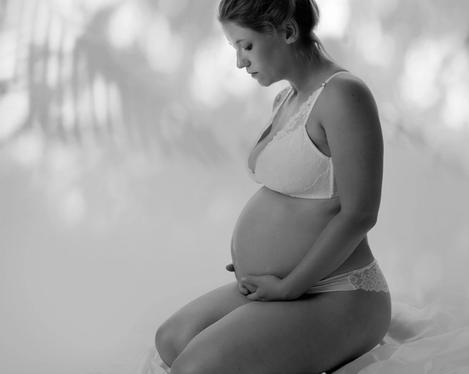 Pregnant woman in side view sitting on floor