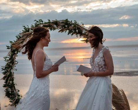 Same-sex female brides read their wedding vows to each other.