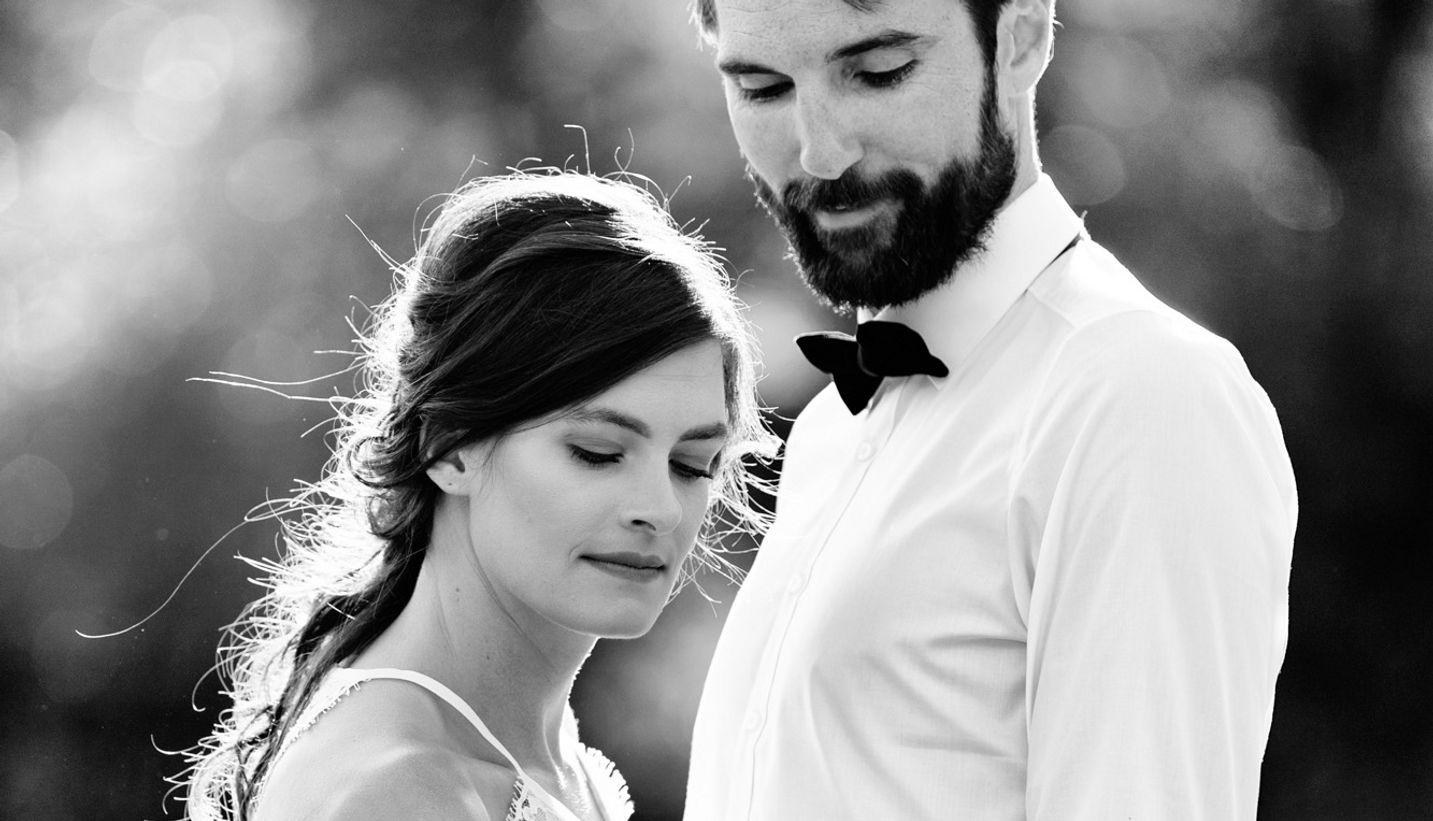 Portrait of bride and groom standing together in black and white