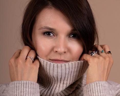 Portrait einer dunkelhaarigen Frau mit beige farbigem Rollkragenpullover