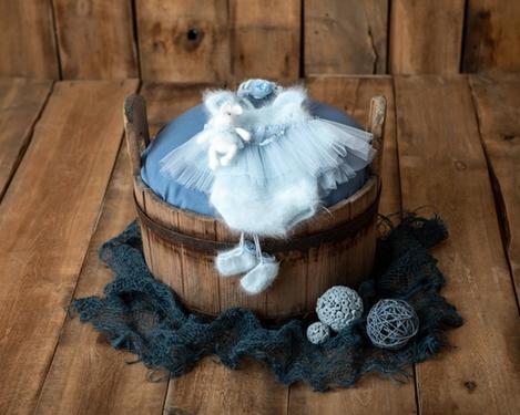 Alter Holzbottich mit hellblauen Mädchen-Babyset zur Neugeborenenfotografie