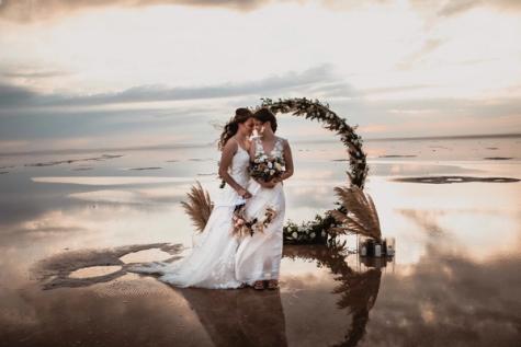 Same-sex female wedding couple at a lake in evening atmosphere