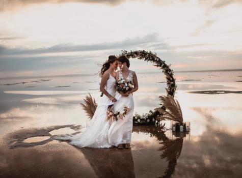 Same-sex female wedding couple at a lake in evening atmosphere
