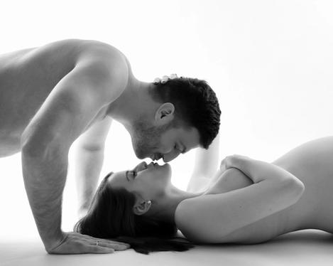 Pregnant woman lying on floor and kissed by partner, b&w shot