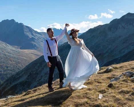Bride and groom dancing happily in the mountains