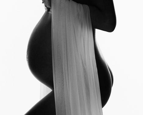 Seitenansicht von einem Babybauch mit Seidentuch vor weißem Hintergrund