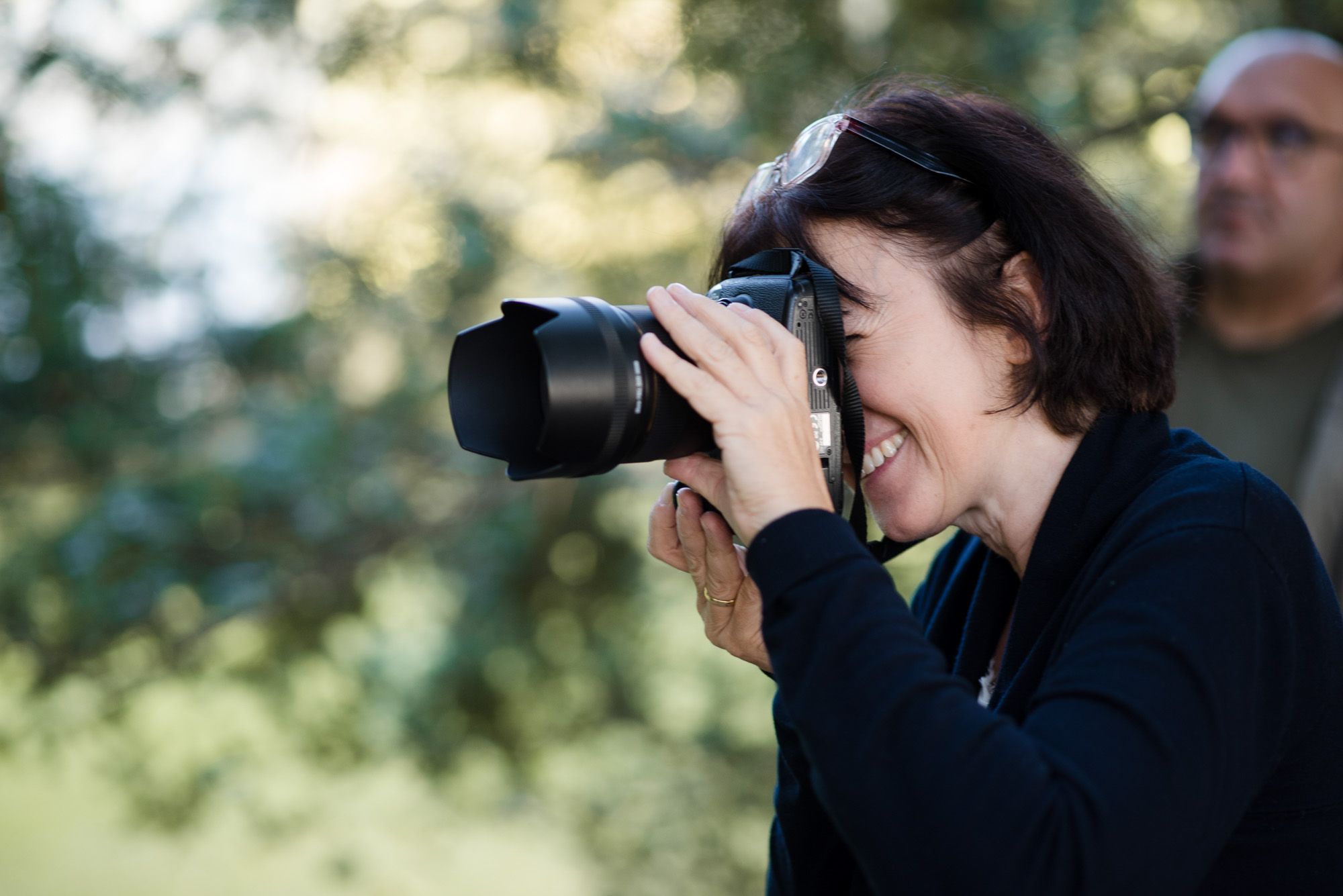 Fotografin in Action mit Camera haltend vor ihrem Gesicht